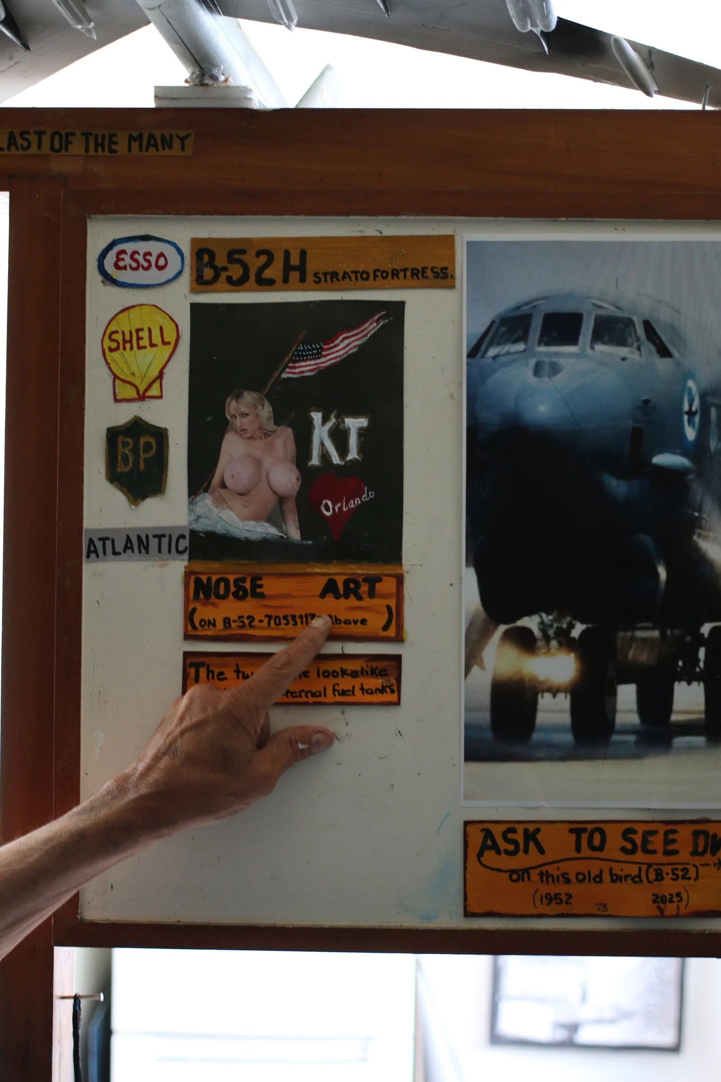 John's hand pointing to an aircraft display beneath a model plane.