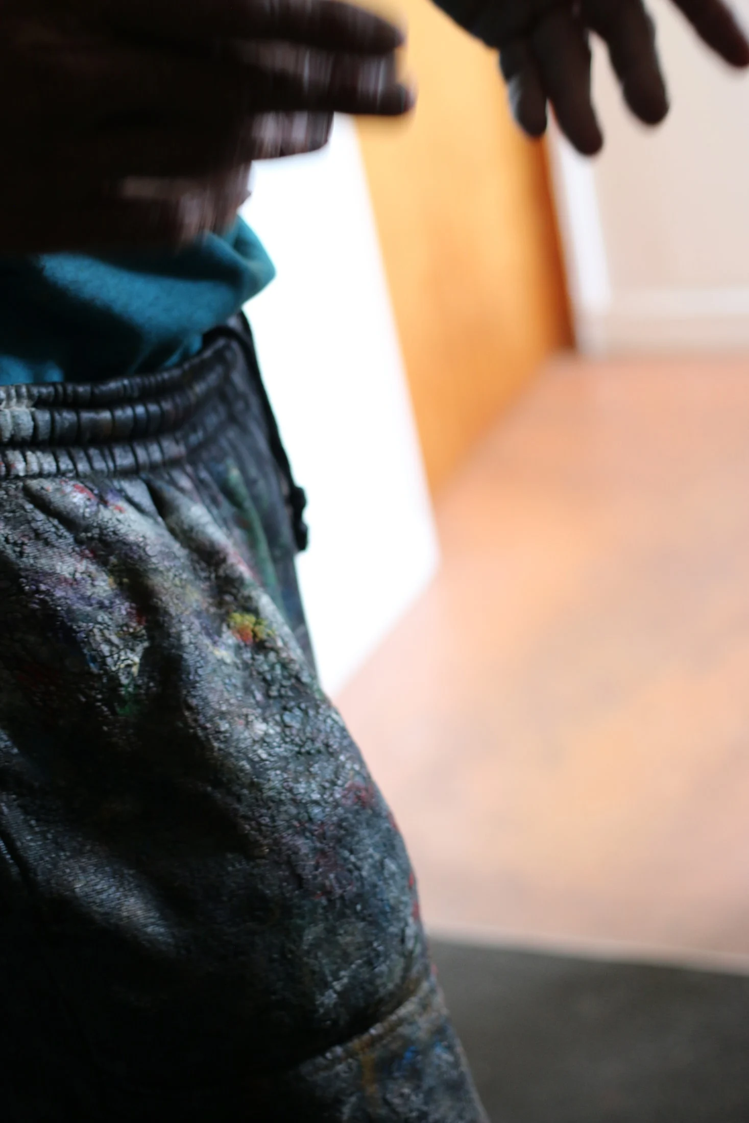 A close view of paint marks on John's jeans.