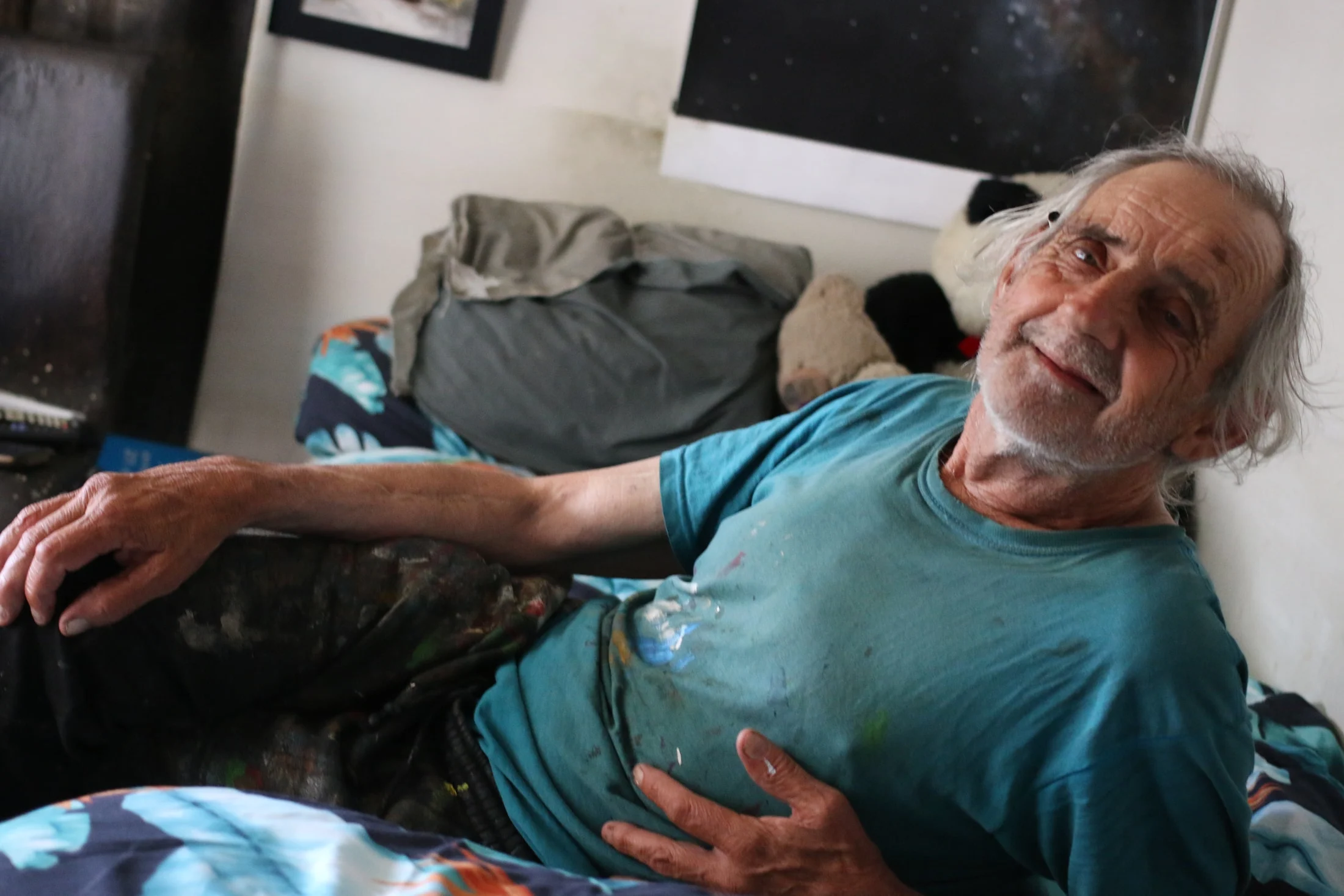 John sitting back in a chair beneath a picture of space.