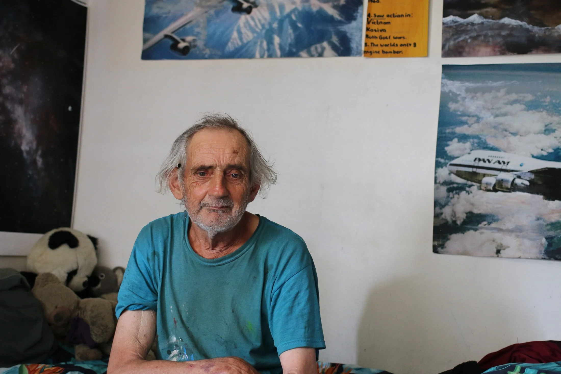 John sitting at home with aircraft and space pictures on the walls behind him.