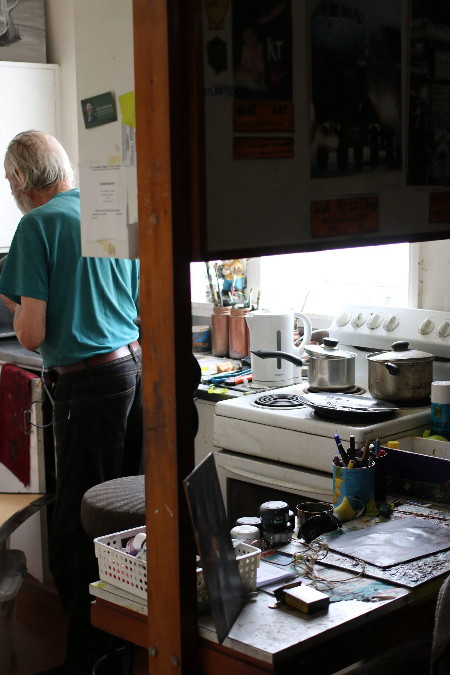 A view through the doorway of John working in his kitchen studio.