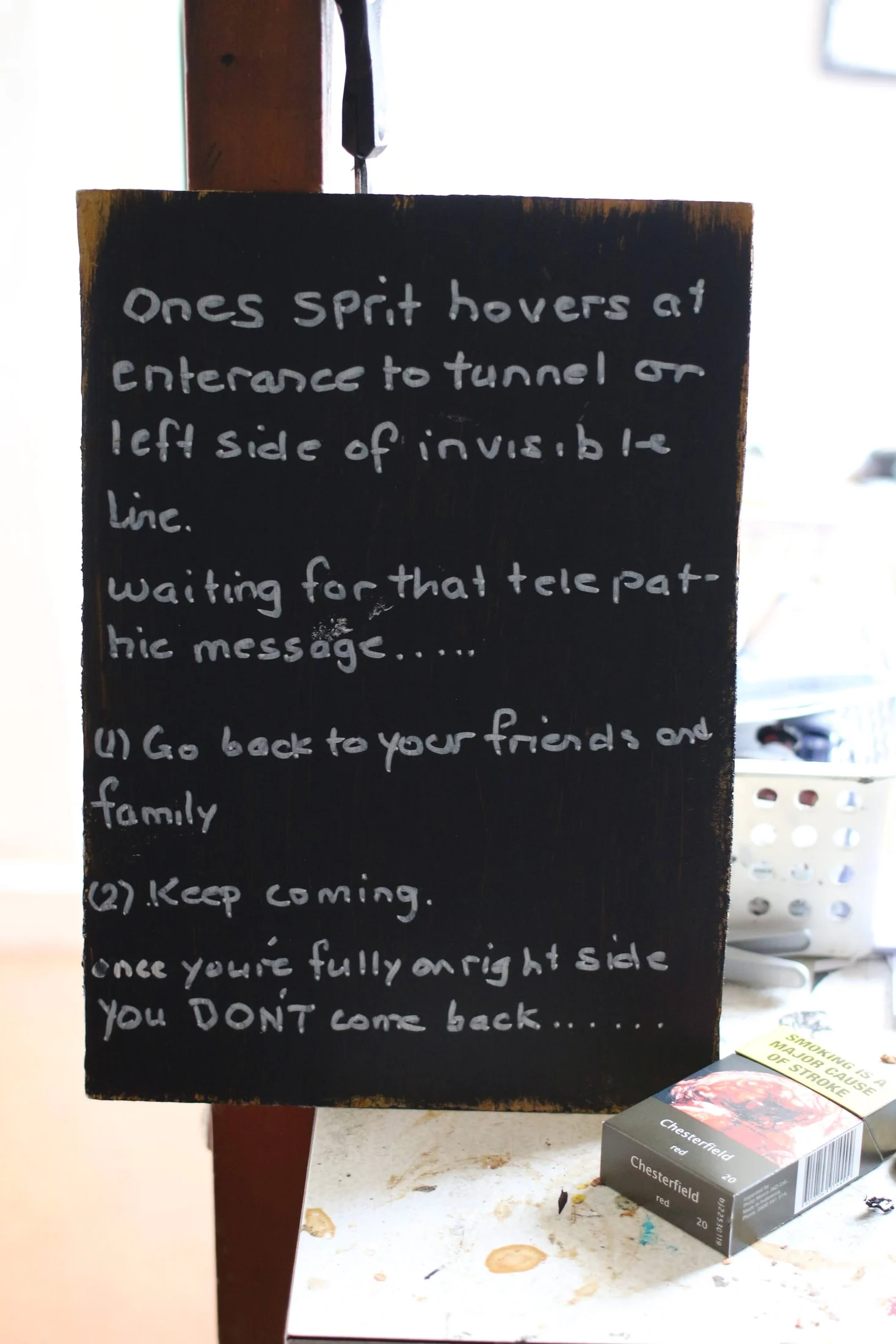 A black board with John's handwritten text about the tunnel and the invisible line.